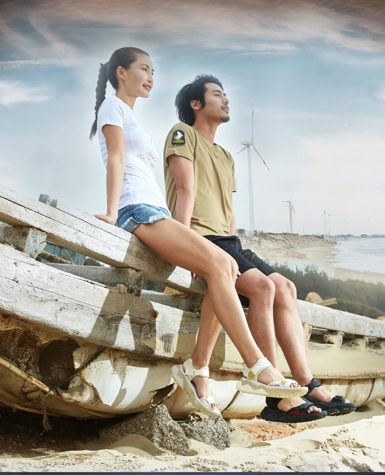 Un hombre y una mujer se sientan en un banco con vistas al océano