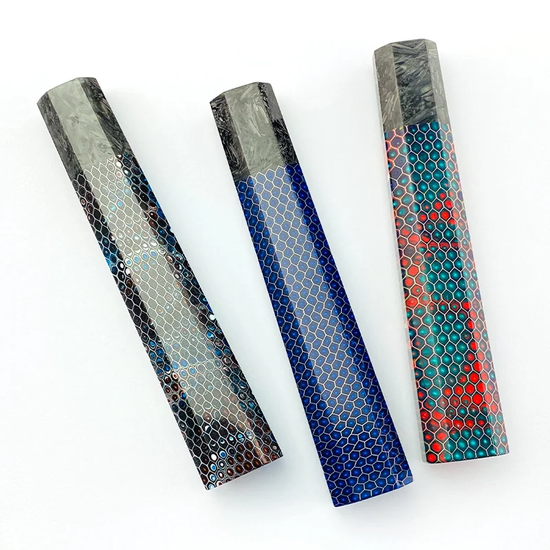 Tres cilindros de colores diferentes están alineados sobre un fondo blanco.