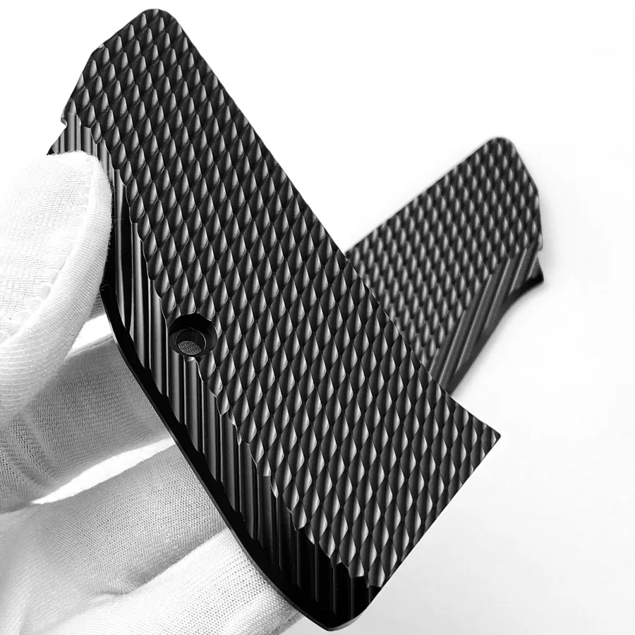 Un objeto en blanco y negro está siendo sostenido por una persona con un guante blanco.