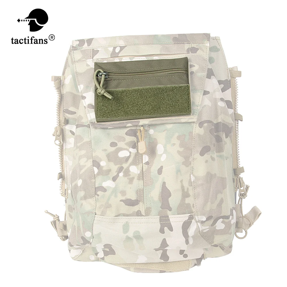Una mochila de camuflaje con una solapa verde y un bolsillo de cremallera