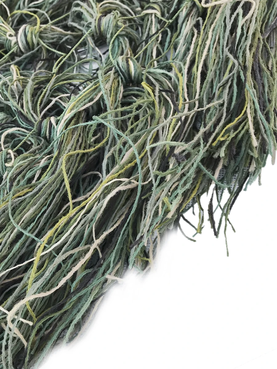 Manta Ghillie en tono jungla desplegada sobre terreno