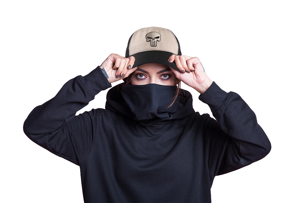 Una mujer que lleva una sudadera con capucha negra y una gorra de béisbol con un cráneo