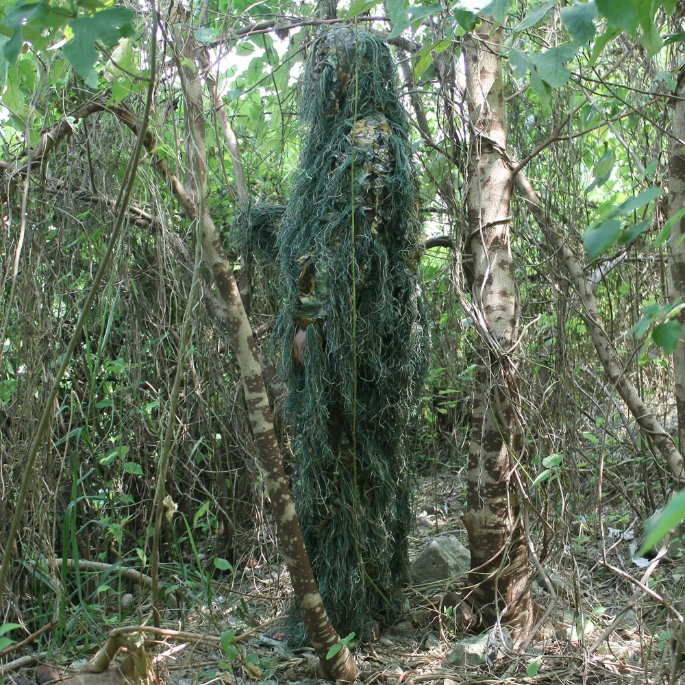 Una persona con traje de camuflaje es el bosque de pie