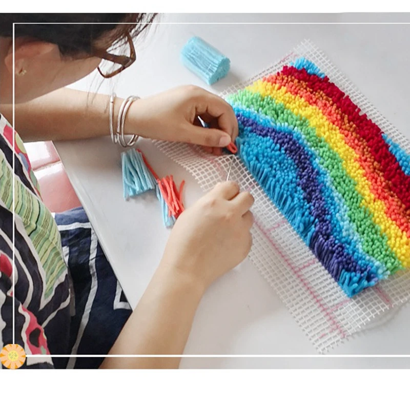 Una mujer está trabajando en un proyecto de artesanía con un hilo de color arcoiris