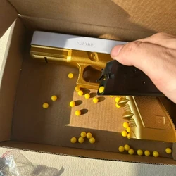 Pistola de juguete dorada y plateada con balas blandas