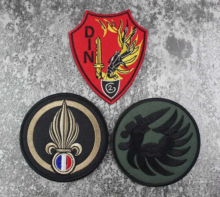 Insignia bordada de la Legión Francesa sobre fondo negro
