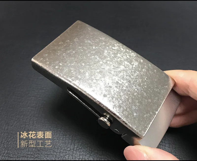 Una persona está sosteniendo una caja de plata con un botón de oro