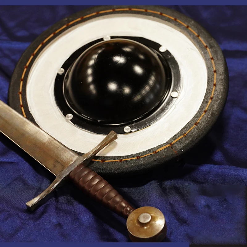 Los soldados HEMA golpean espadas de acero, pequeños escudos redondos, equipo de protección, bordes de escudo de piel de vaca