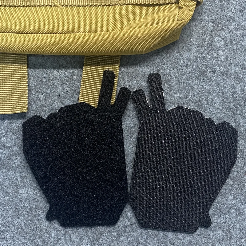 Dos guantes negros con señales de paz en ellos