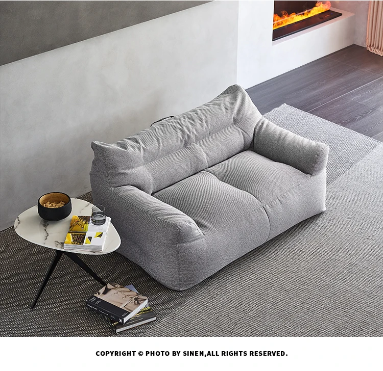 Un sofá gris con una chimenea en el fondo