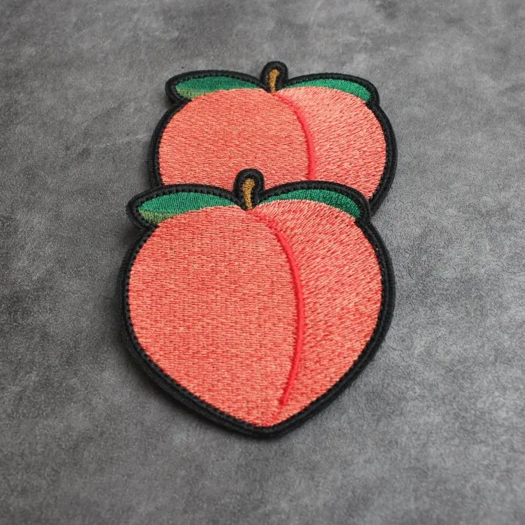 Parche bordado con diseño de durazno sobre superficie textil