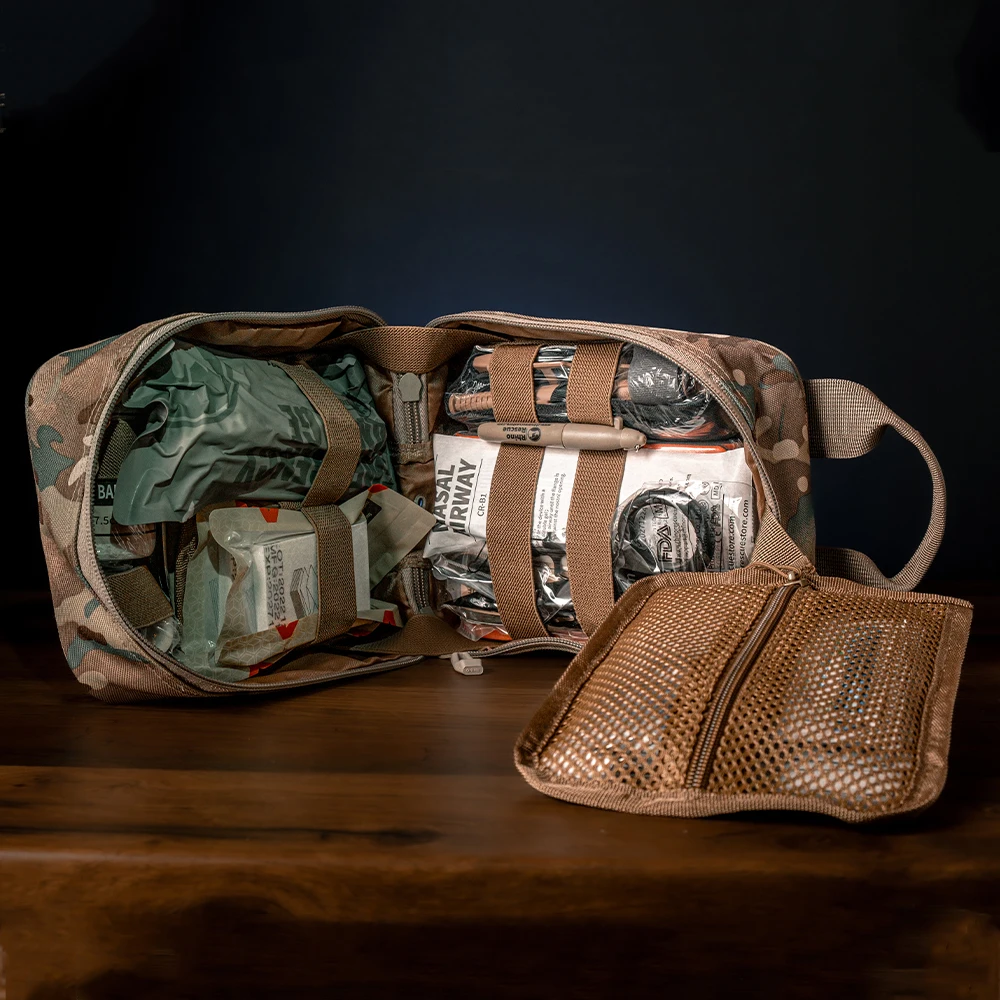 Una bolsa con un bolsillo en el costado está abierta y llena de varios artículos.