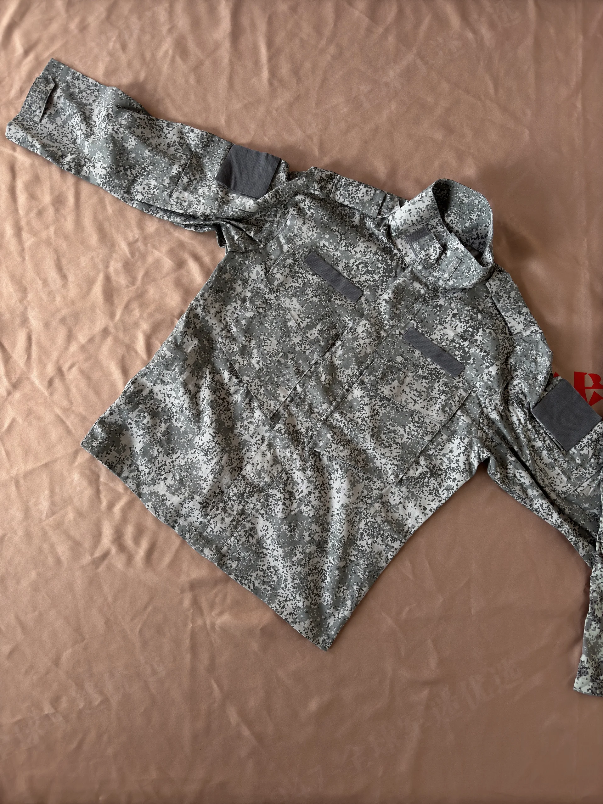 Una camisa de camuflaje se encuentra en una superficie marrón