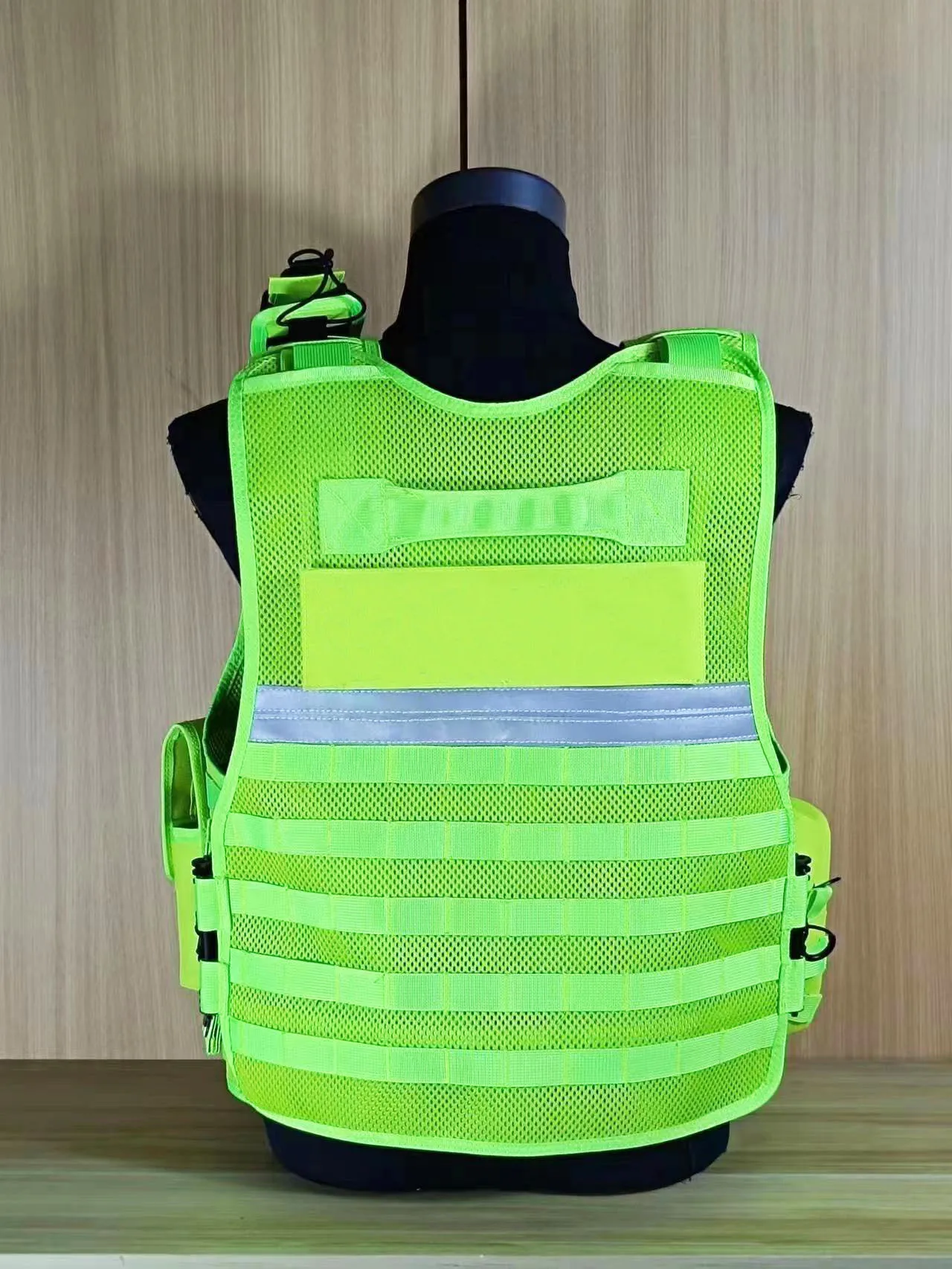 Un chaleco amarillo con una capucha negra está colgando de un maniquí