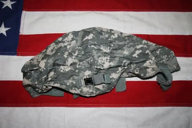 Un sombrero de camuflaje está encima de una bandera