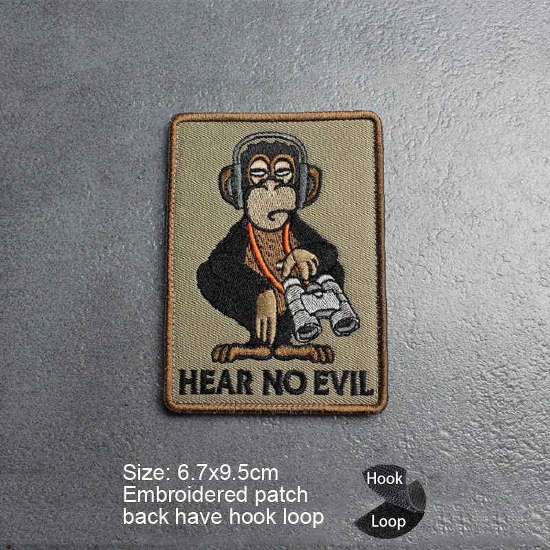Un parche con un mono que dice no oye no escuchar mal
