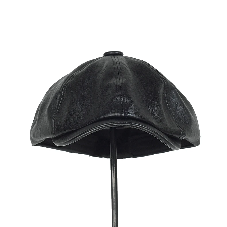 Vista de las gorras planas retro de cuero PU
