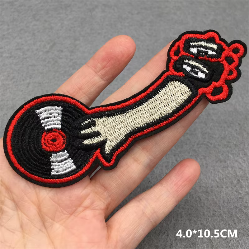 Parche bordado con diseño de guitarra en llamas sobre fondo oscuro
