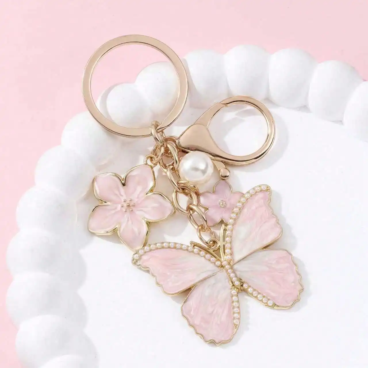 Portachiavi con perla en forma de mariposa y flor metálico - imagen 2