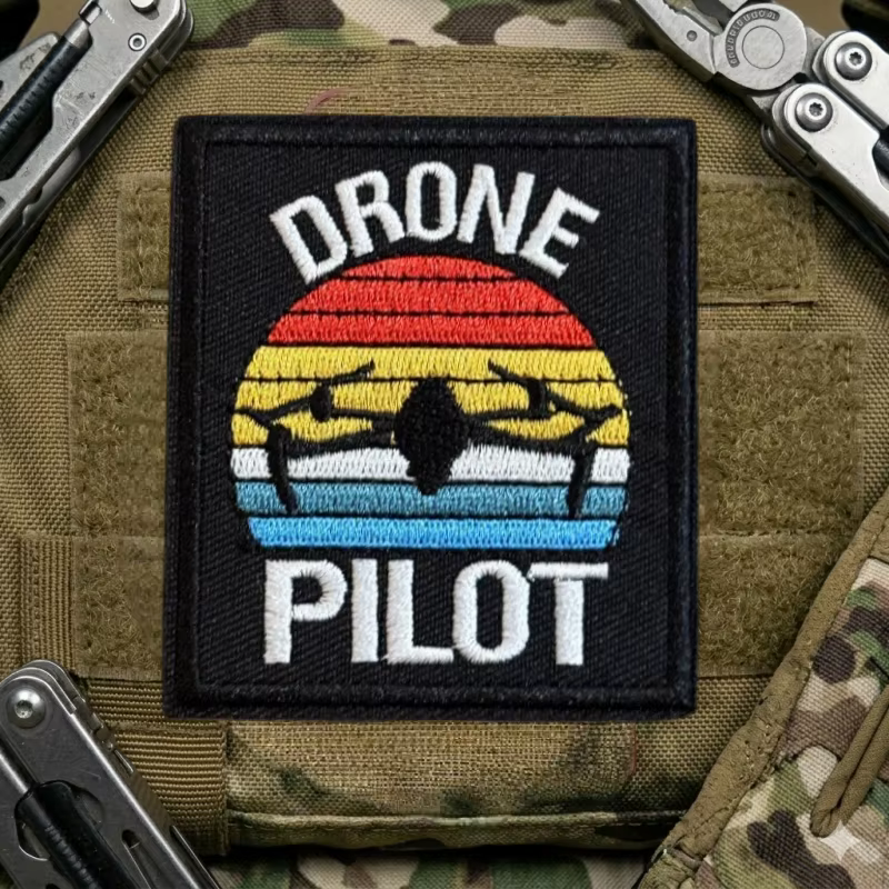Insignia con base para fijación y acabado bordado