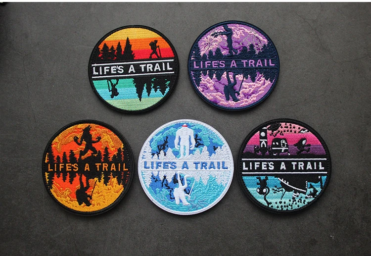 Parche bordado LIFE'S A TRAIL con diseño de paisaje