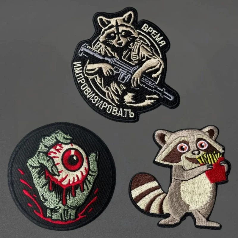 Parche bordado de mapache con mano de zombi y ojo (terror táctico)
