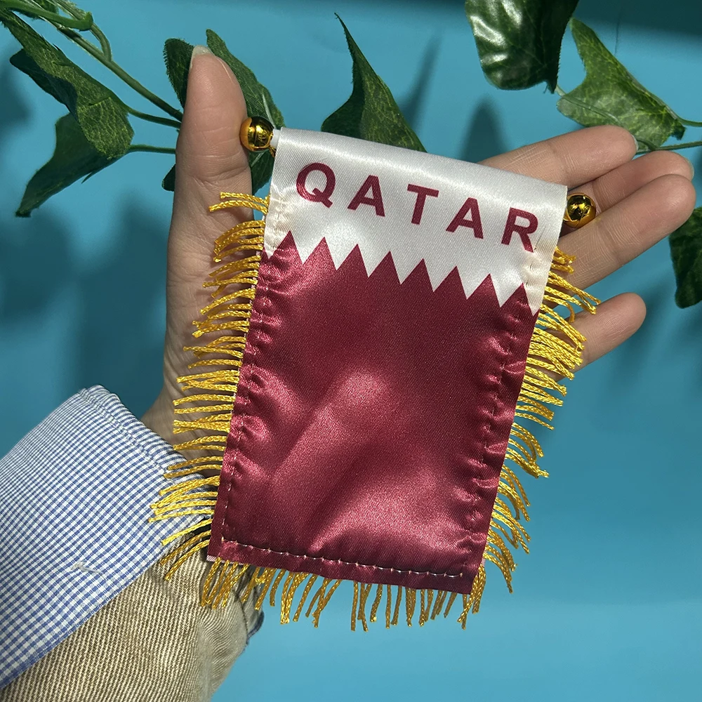 Bandera de Qatar ondeando en ventanilla de coche
