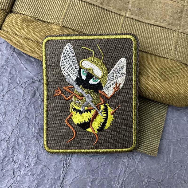 Parche bordado de abeja táctico sobre superficie de mochila
