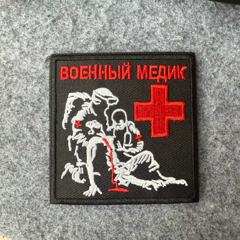 Parche táctico bordado con diseño de cruz roja y escena de rescate