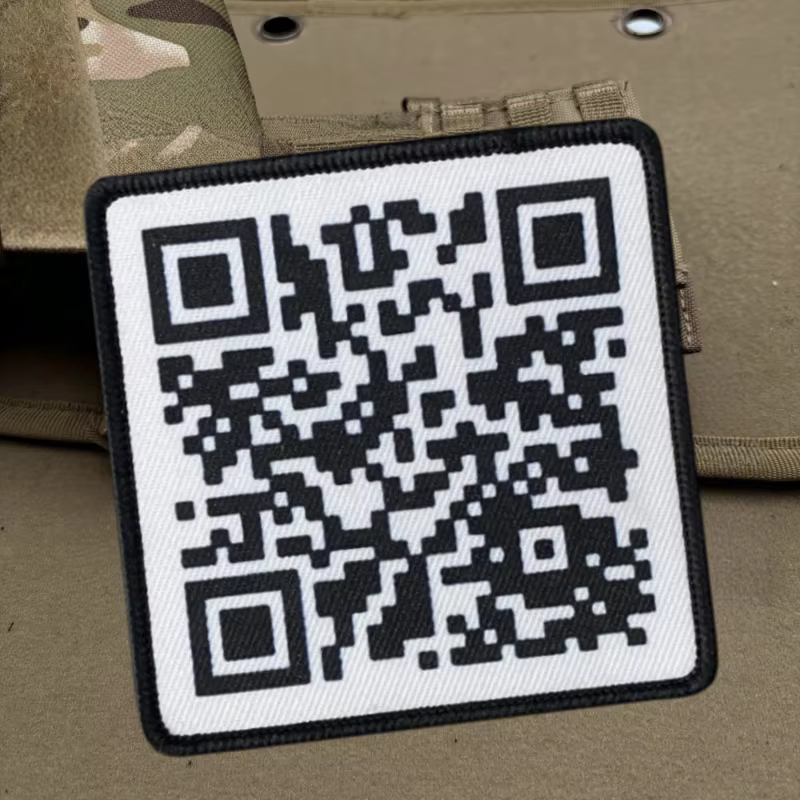 Parche táctico con código QR en fondo oscuro