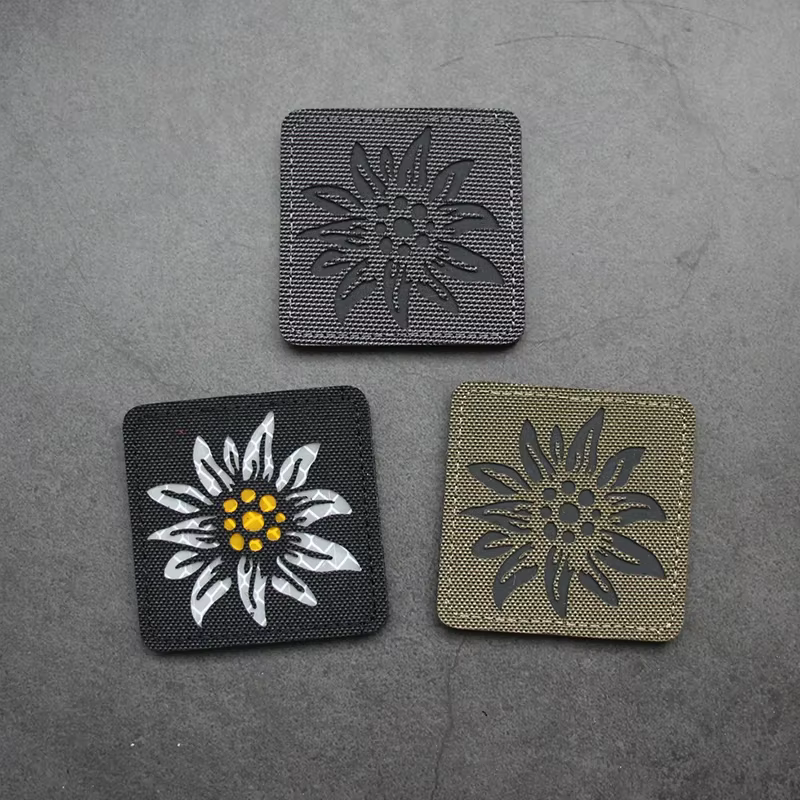 Insignia de moral Edelweiss reflectante luminosa con diseño camuflaje