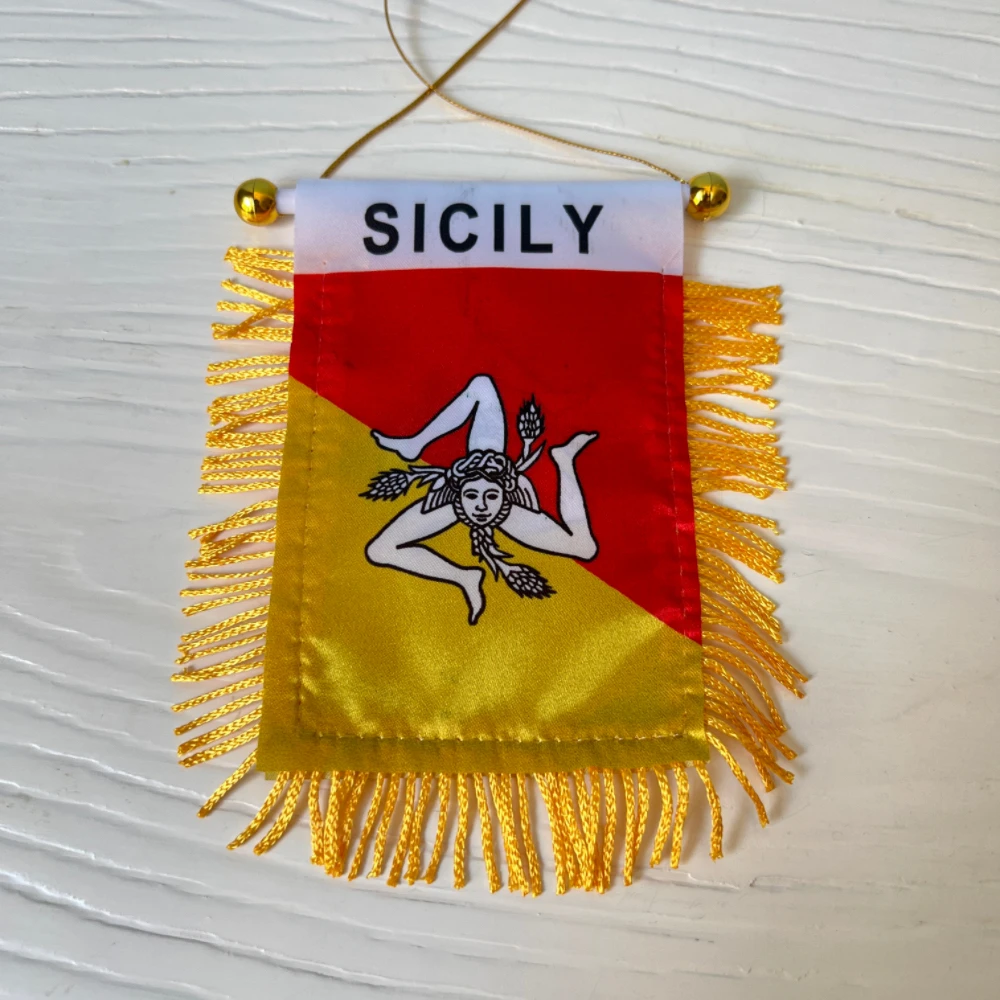 Detalle del estampado de la trinacria sobre el fondo rojo y amarillo