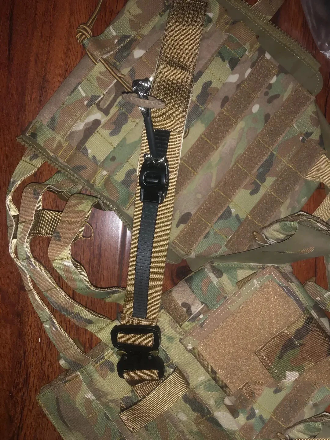 Ejemplo de la correa fijada a un chaleco Molle en entorno de campo