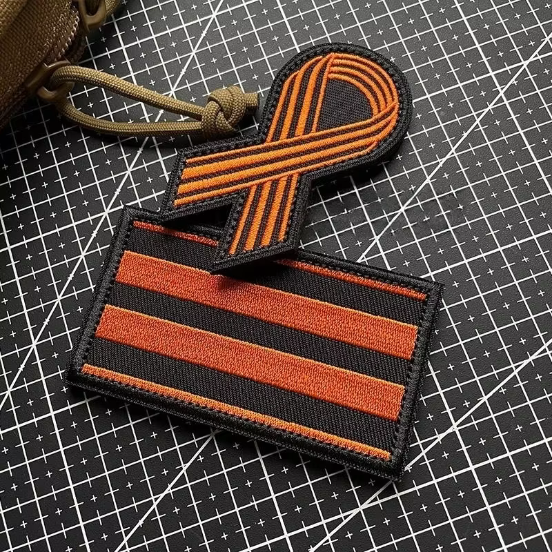 Parche frontal con detalle del bordado y los colores naranja y negro