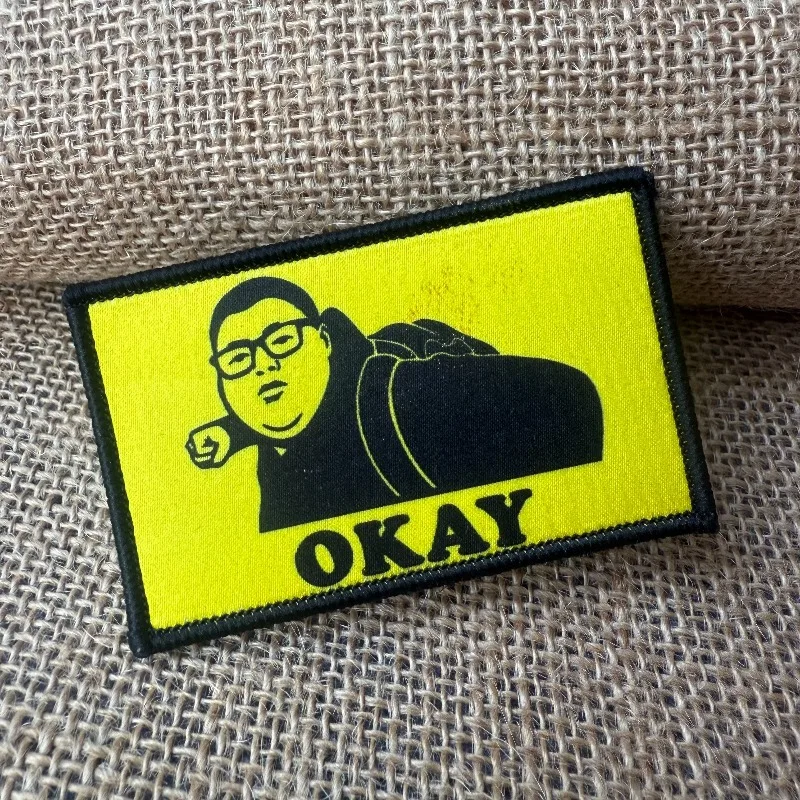 Parche meme “OKAY” con diseño de hombre con gafas
