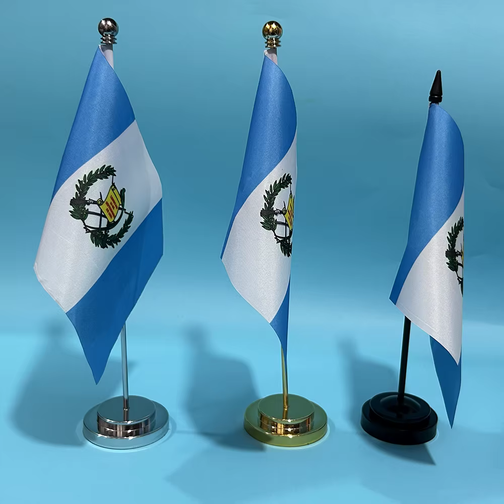 Bandera de Guatemala en mástil de escritorio sobre superficie de madera