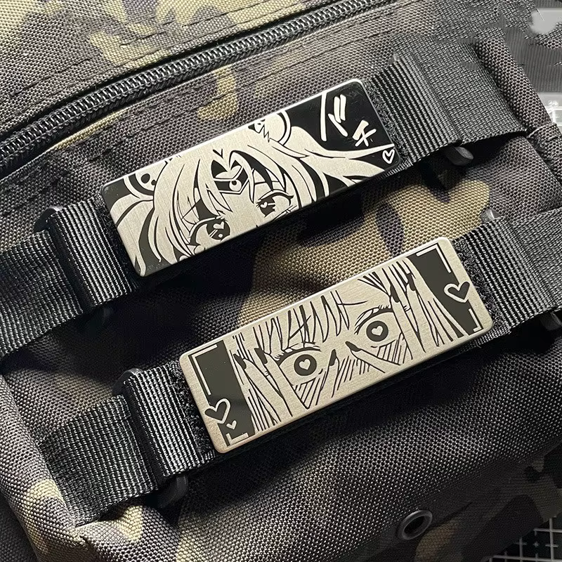 Detalle del parche metálico con diseño de cara tímida y ojos brillantes