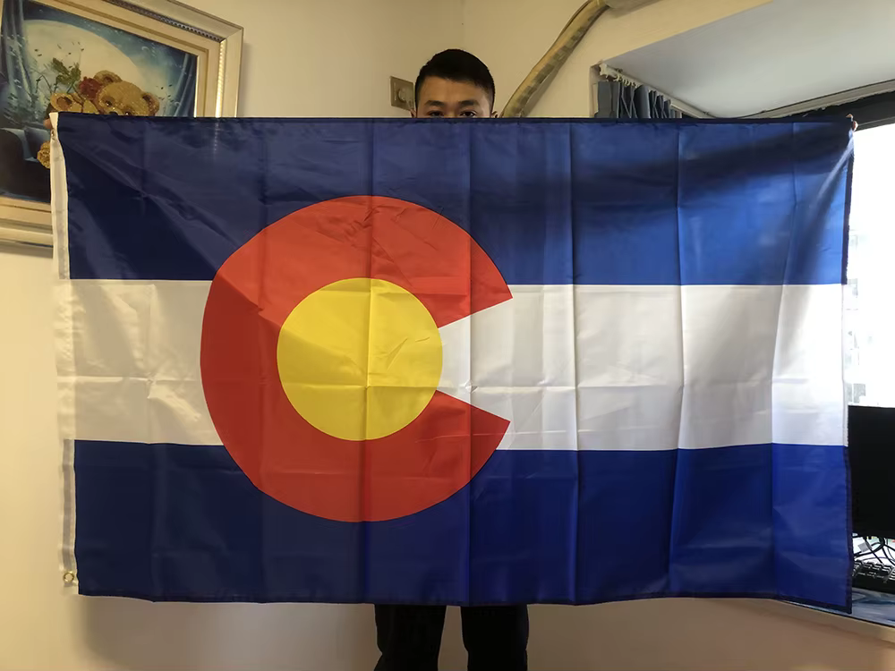Bandera del estado de Colorado ondeando con el diseño oficial de franjas y letra C