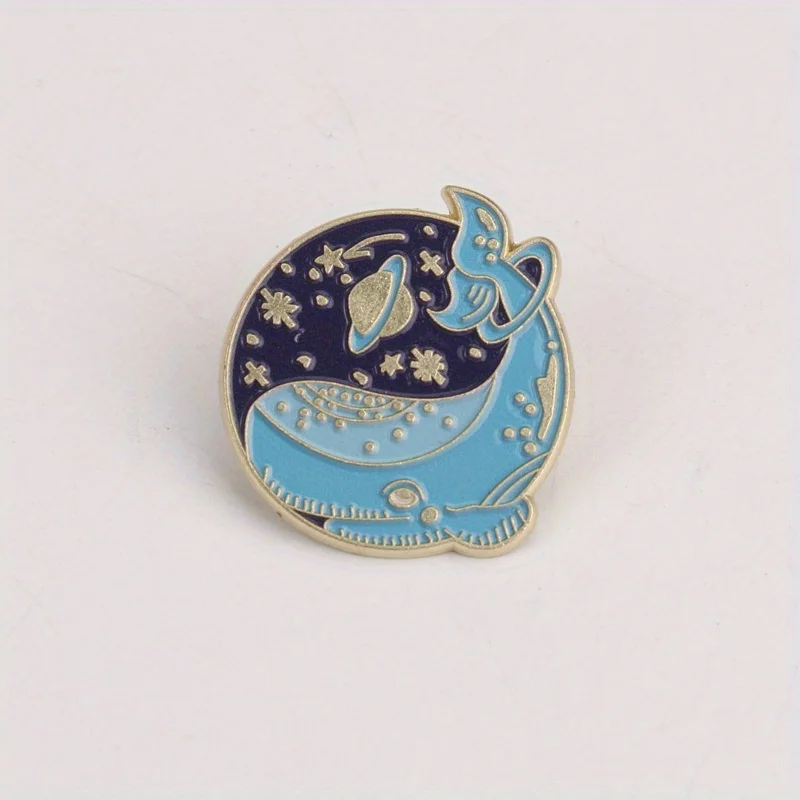 Pin táctico ballena zafiro con estrellas doradas y anillos Saturno