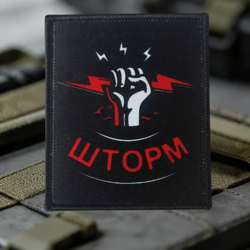 Insignia con sistema de fijación para mochilas