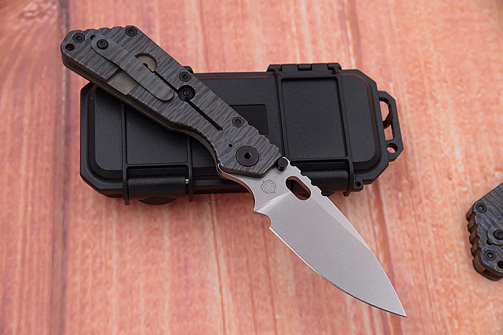 Cuchillo cerrado junto a la caja táctica de embalaje
