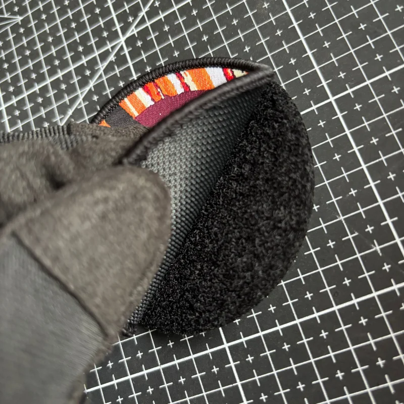 Parche bordado con diseño de héroe de llama en fondo oscuro