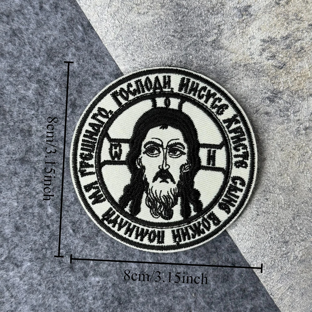Detalle del bordado que muestra la textura del hilo y el diseño de la cruz