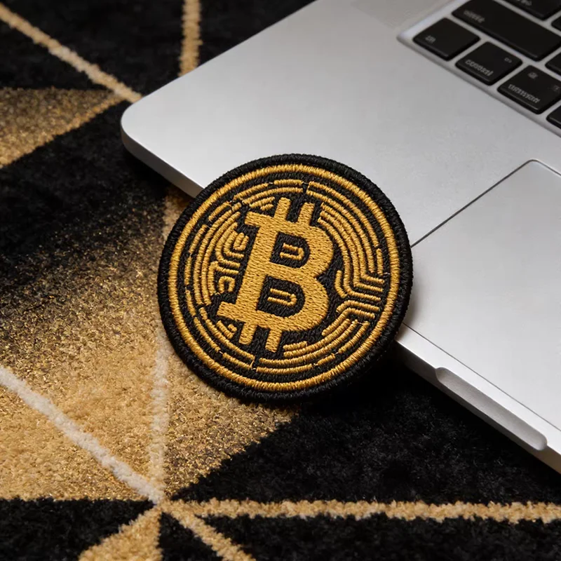 Detalle del parche de metal Bitcoin con acabado dorado