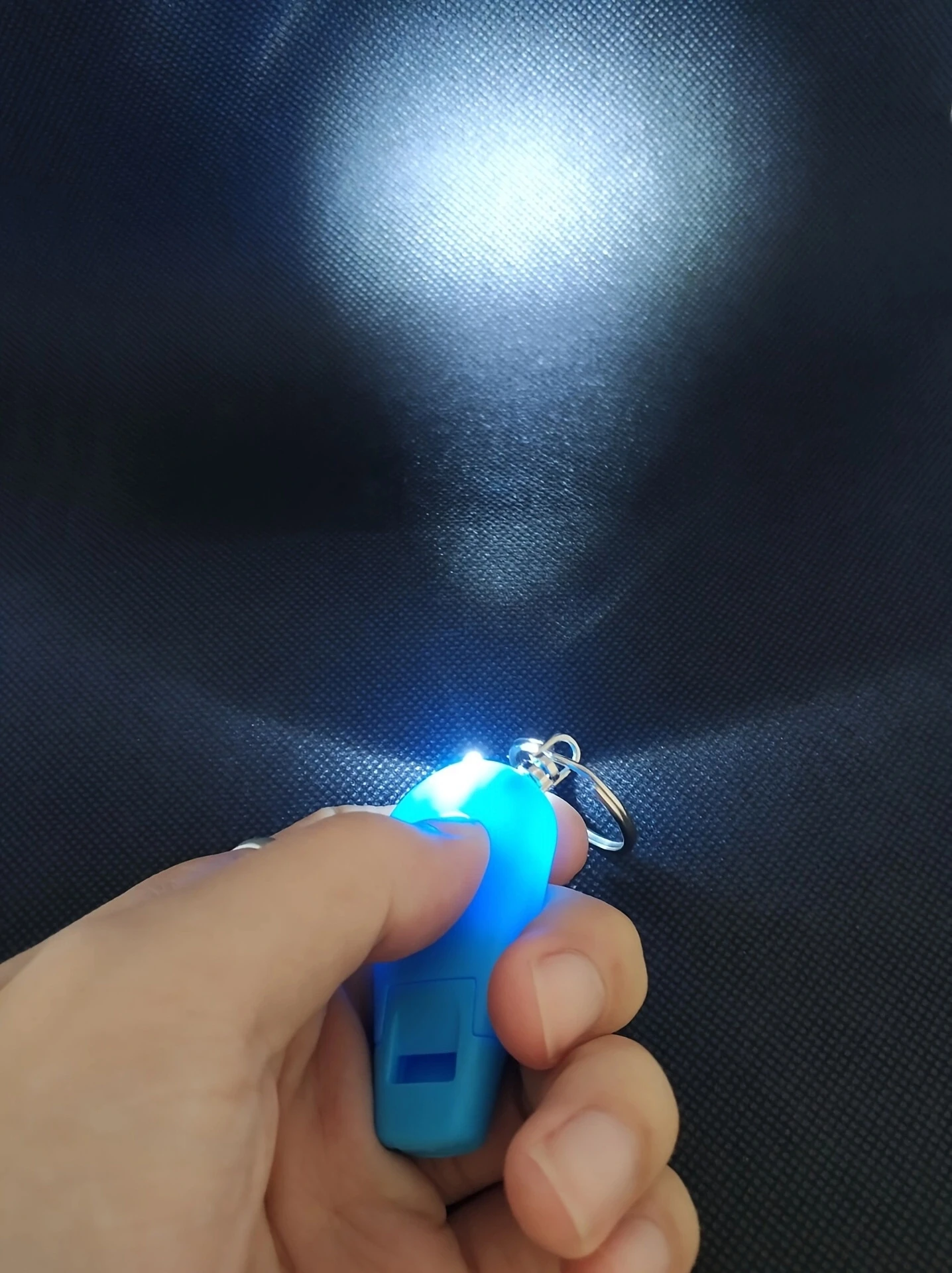 Mini llavero LED con silbato en mano
