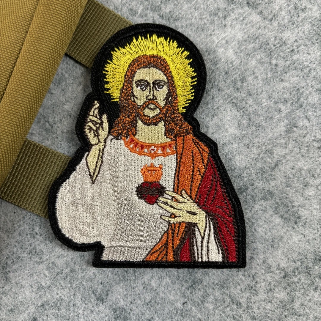 Parche bordado de cruz de Jesús con bordado detallado sobre fondo oscuro