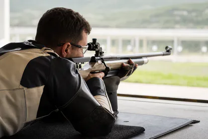 Tirador deportivo entrenando respiración y estabilidad con protección ocular.