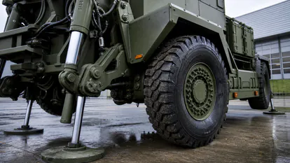 Detalle de rueda, suspension y estabilizadores de un vehiculo de artilleria sobre ruedas.