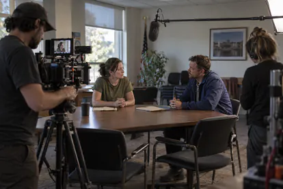 Equipo de cine grabando un diálogo de ficción en una sala de reuniones